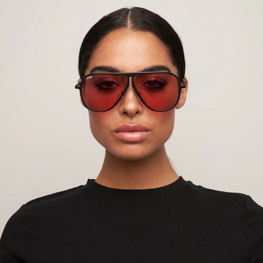 Person wearing a black t-shirt and red sunglasses against a plain background