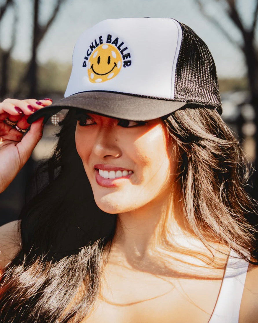 Woman wearing a cap with a smiley face design outdoors