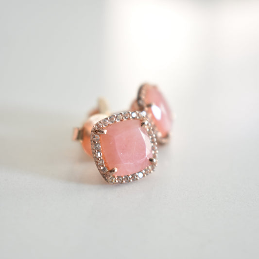 Pink ring with a clear gemstone on a light gray background