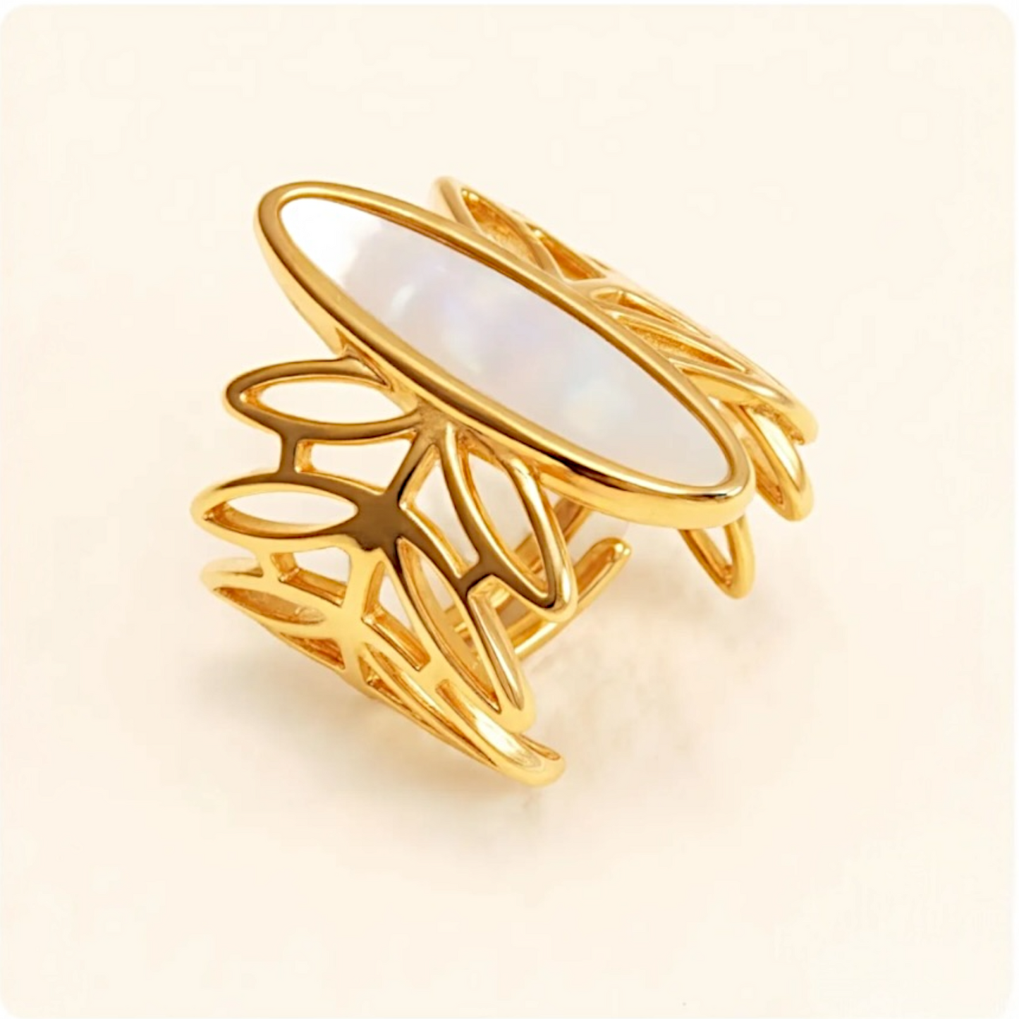 Gold ring with a white stone on a light beige background