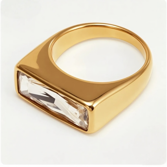 Gold ring with a rectangular gemstone on a white background