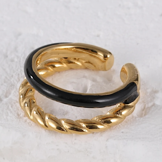 Gold and black ring on a textured white surface