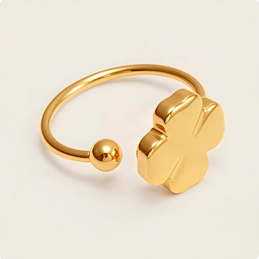 Gold ring with a clover-shaped design on a beige background