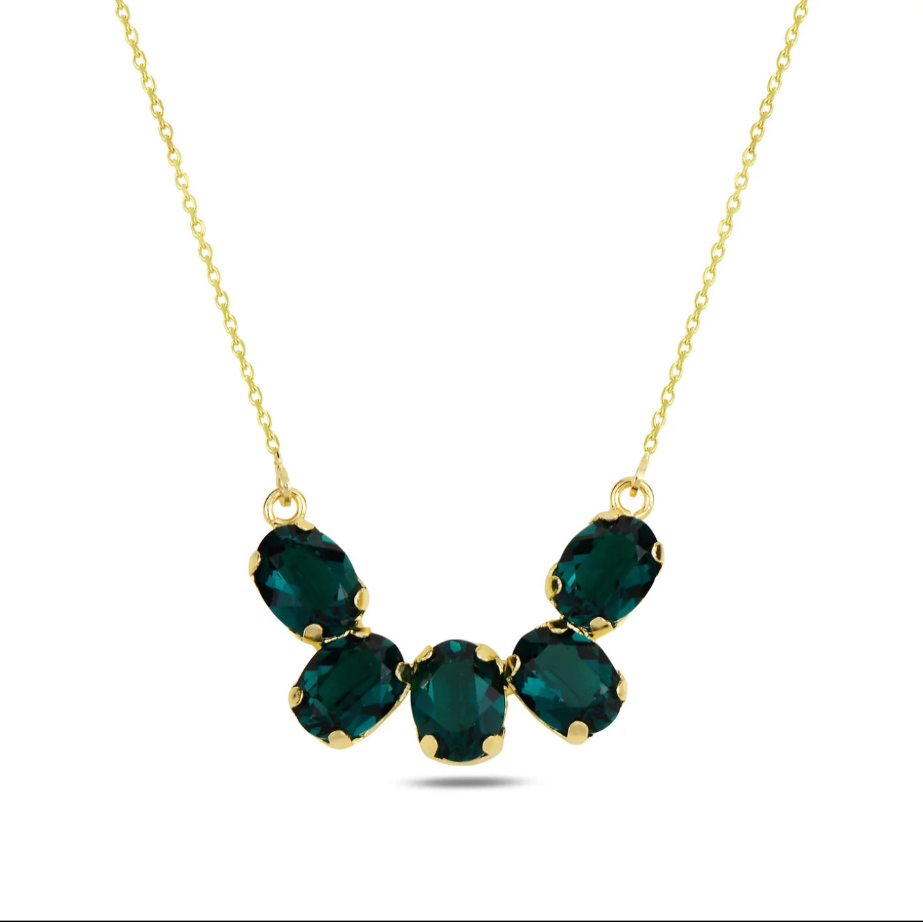 Gold necklace with green Swarovski crystals on a white background