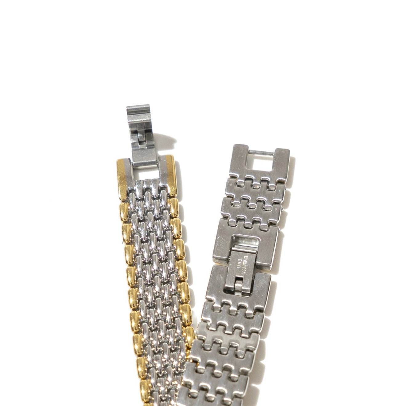Two metallic watch bracelets on a white background