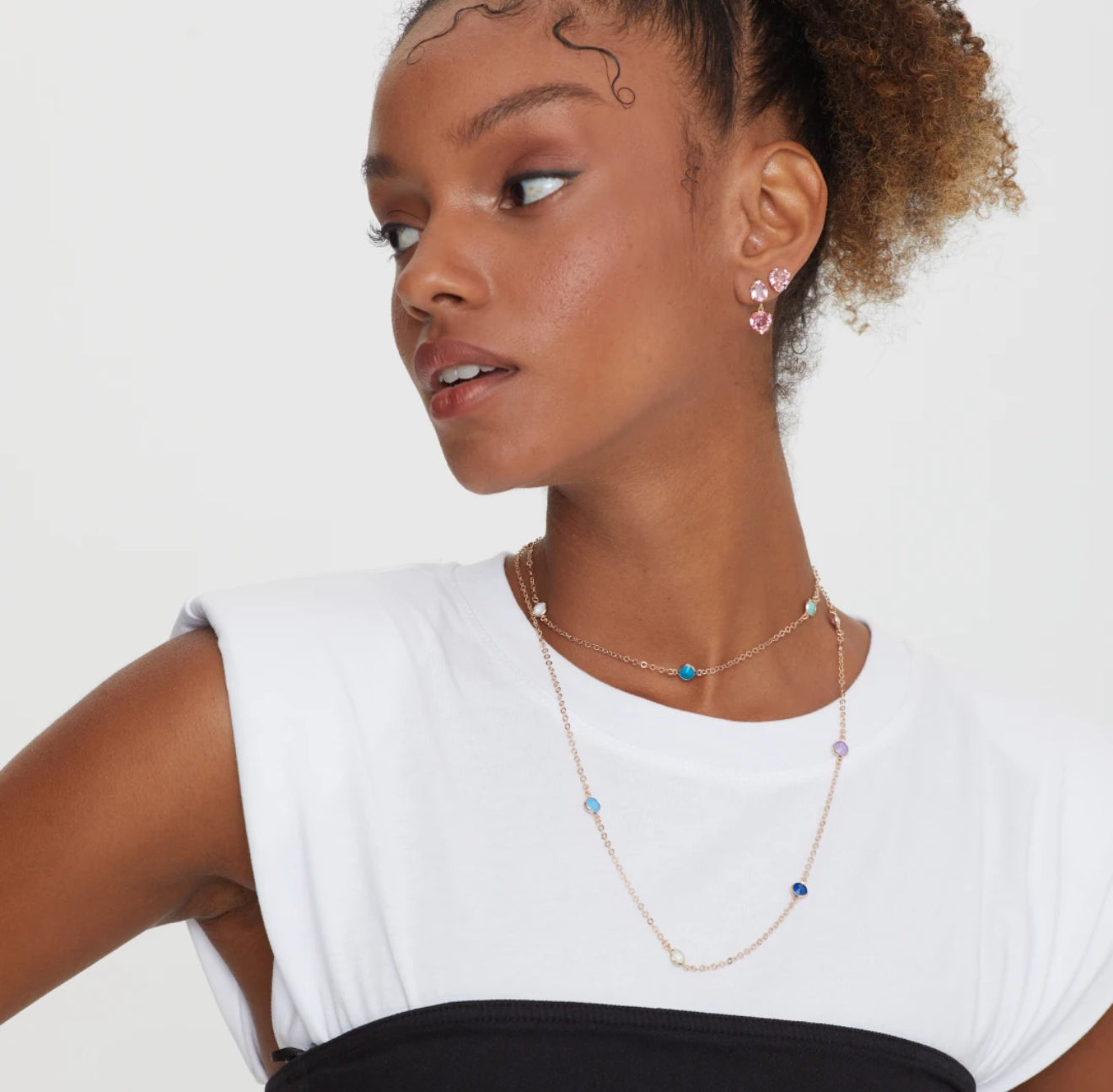 Woman wearing a delicate necklace with a white background