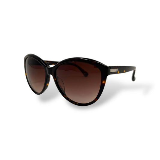 A pair of Calvin Klein sunglasses with a brown tortoise design and brown gradient lenses.