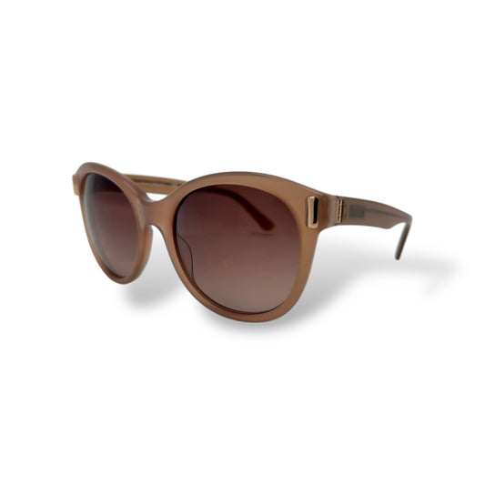A pair of Calvin Klein sunglasses with a beige cat-eye frame and brown gradient lenses.
