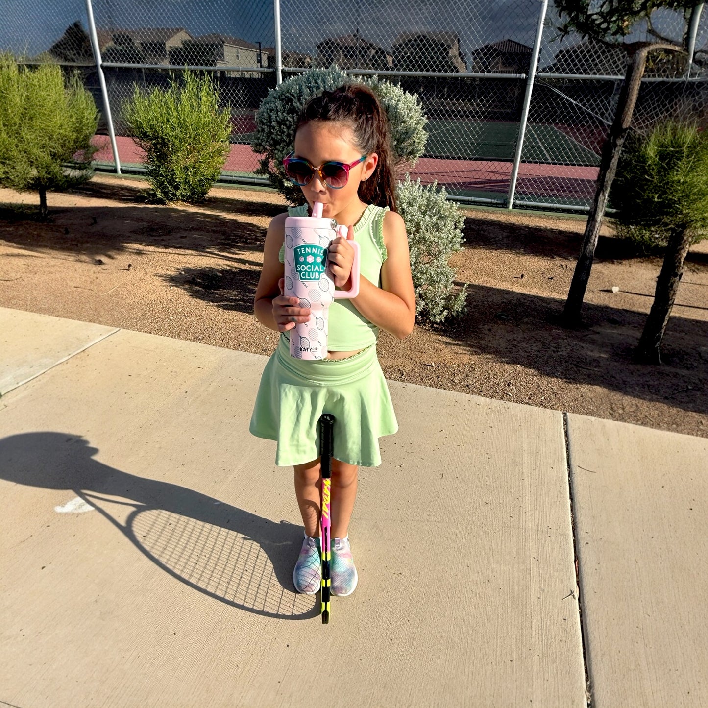 Young girl drinking out of a tumbler outside of tennis courts
Pink and green tennis club tumbler
38 ounces
includes reusable plastic straw
all-day chill or heat