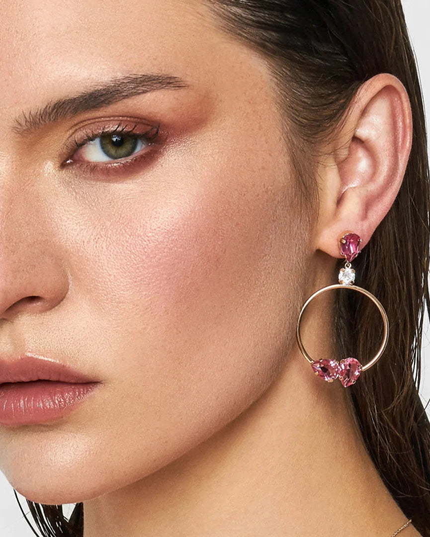 Close-up of a woman wearing pink hoop earrings with heart-shaped crystals.
Material: Sterling Silver, Rose Gold Plated, Swarovski Crystals
Color: sterling silver, rose gold, white, and pink
Measurement: 1 mm thickness, 5 cm length, 3 cm width