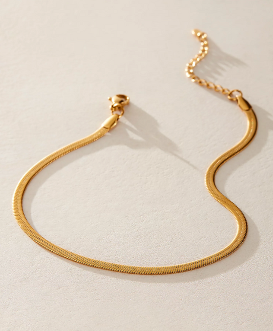 Gold bracelet on a light beige background