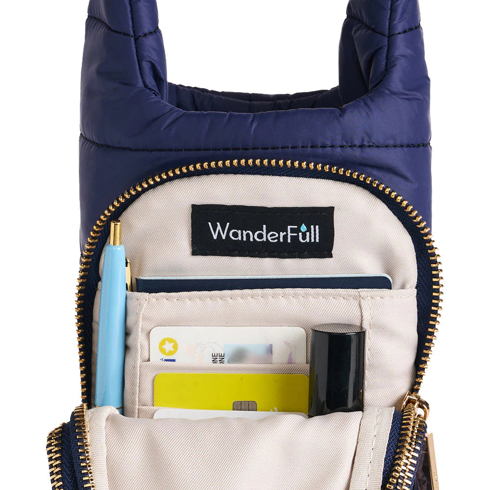 Navy crossbody bag with gold zippers, showing interior compartments and WanderFull logo.