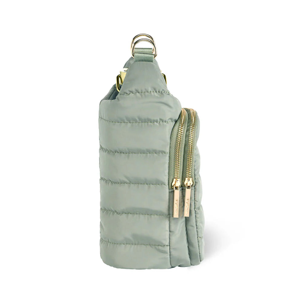 Light green quilted bag with gold zippers on a white background