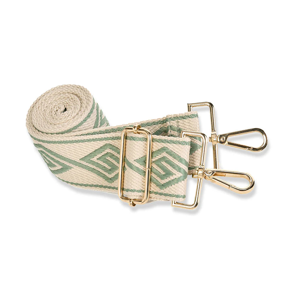 Roll of green and beige patterned strap with gold metal clasps on a white background