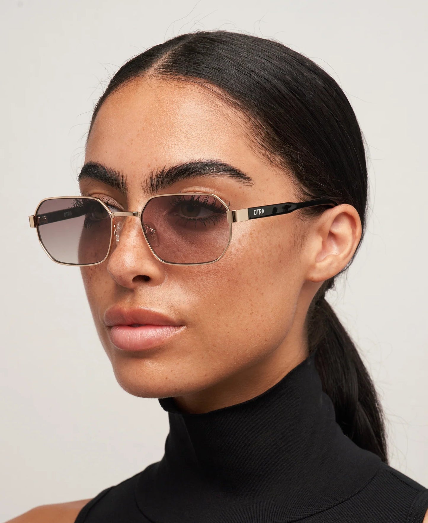 Woman wearing sunglasses with a plain background