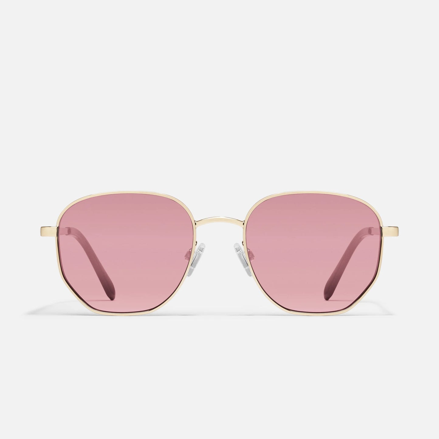 Sunglasses with pink lenses and gold frames on a white background