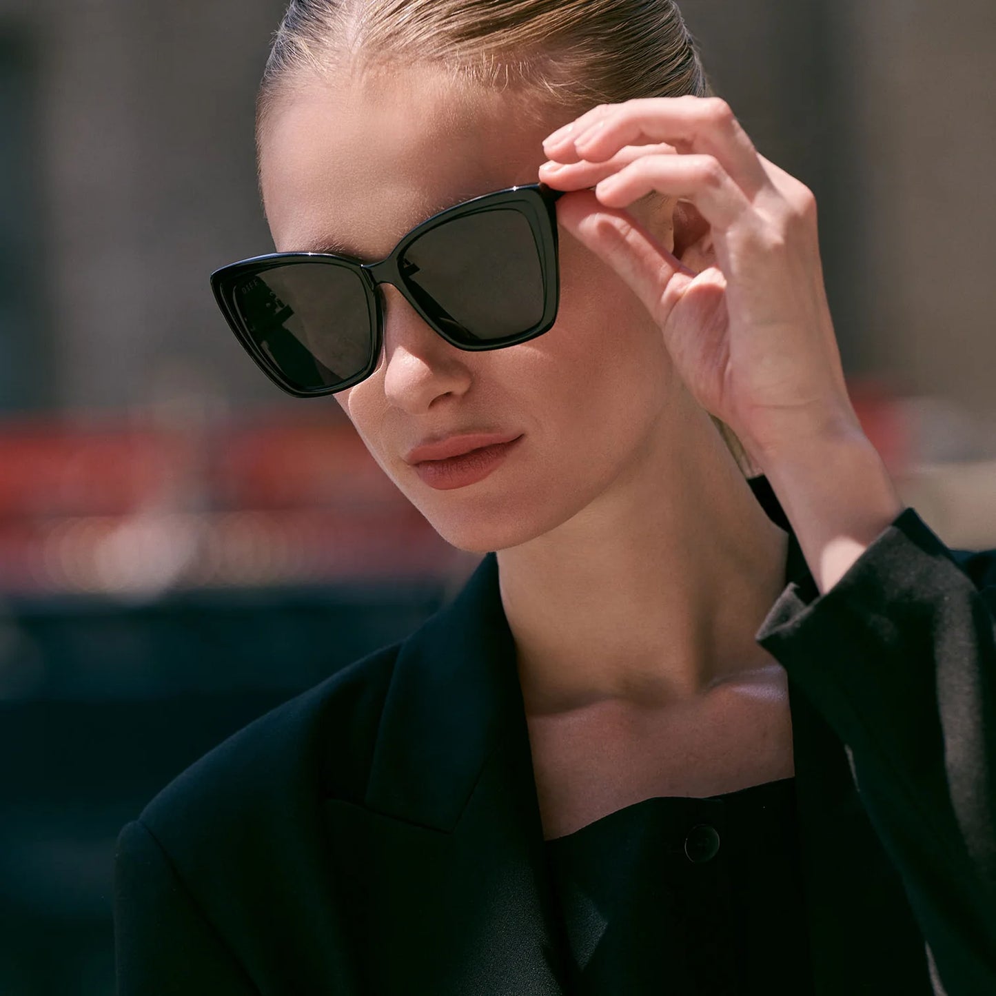 Woman wearing black sunglasses with a blurred background