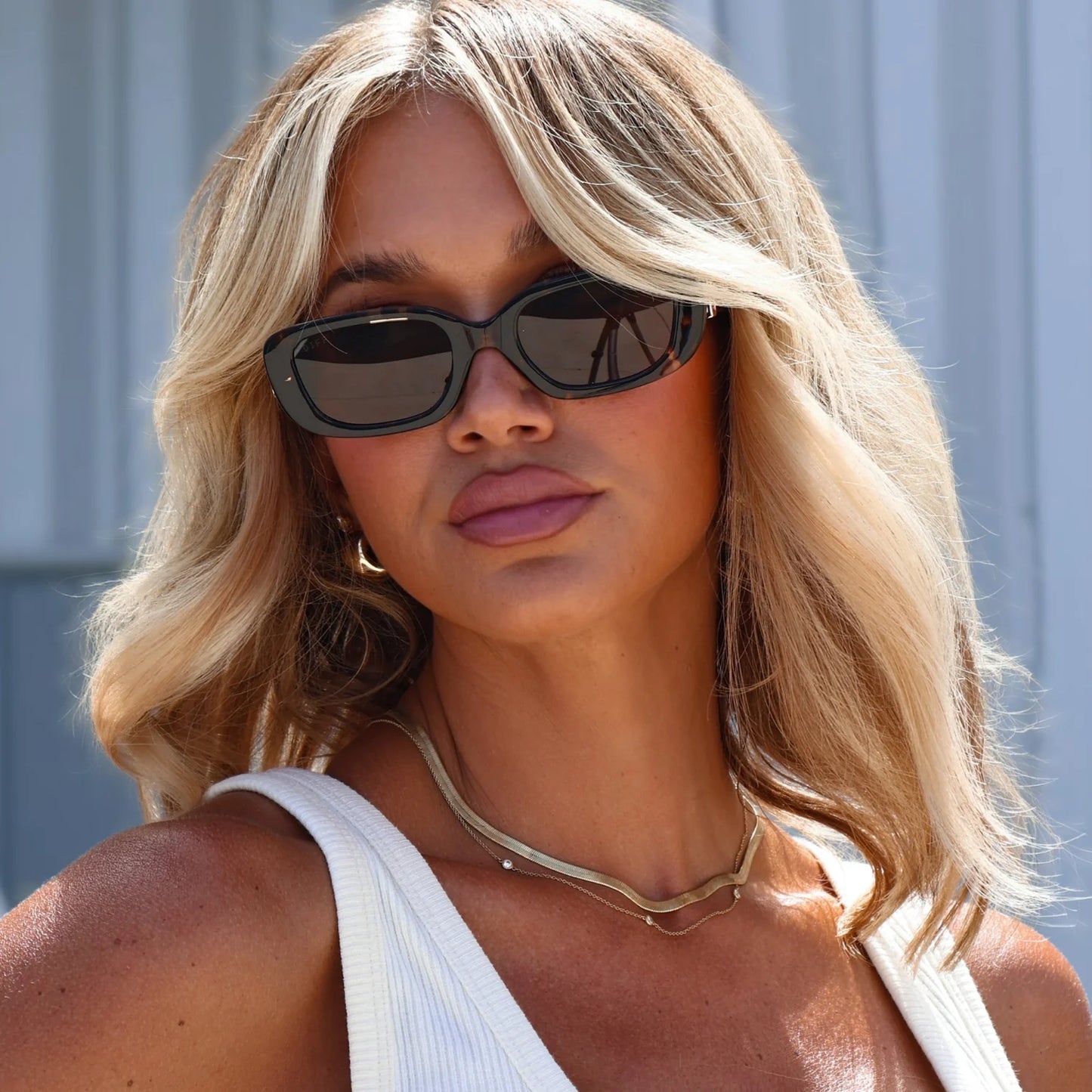 Woman wearing sunglasses with a neutral background