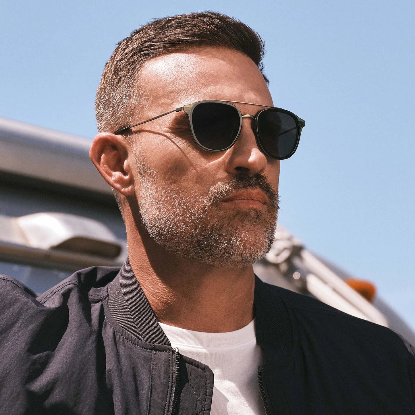 Man wearing sunglasses with a clear blue sky background
