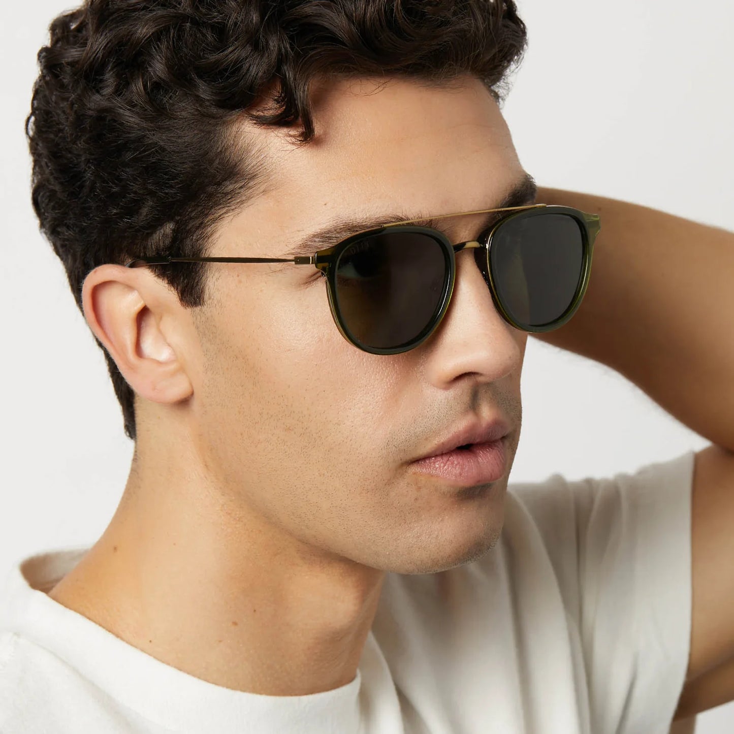 Man wearing dark sunglasses with a neutral background