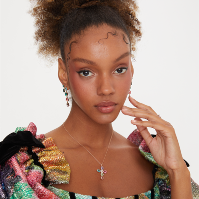Woman wearing a colorful, patterned outfit with a neutral background