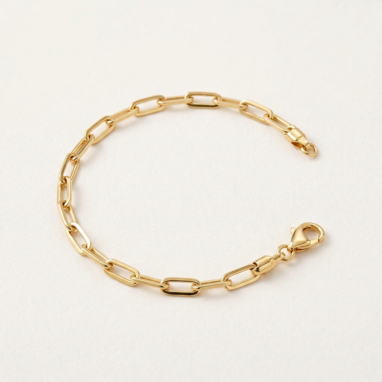 Gold chain bracelet on a light gray background