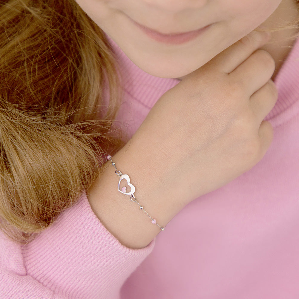 Age Group: Adorable for Toddlers, Young Girls & Preteens; Safe for Sensitive Skin
Material: 925 Sterling Silver
Bracelet Size: 5 inches with extension up to 6", heart & round beads (pink enamel); Adjustable
Metal Stamp: 925
picture of young girl wearing the silver heart bracelet