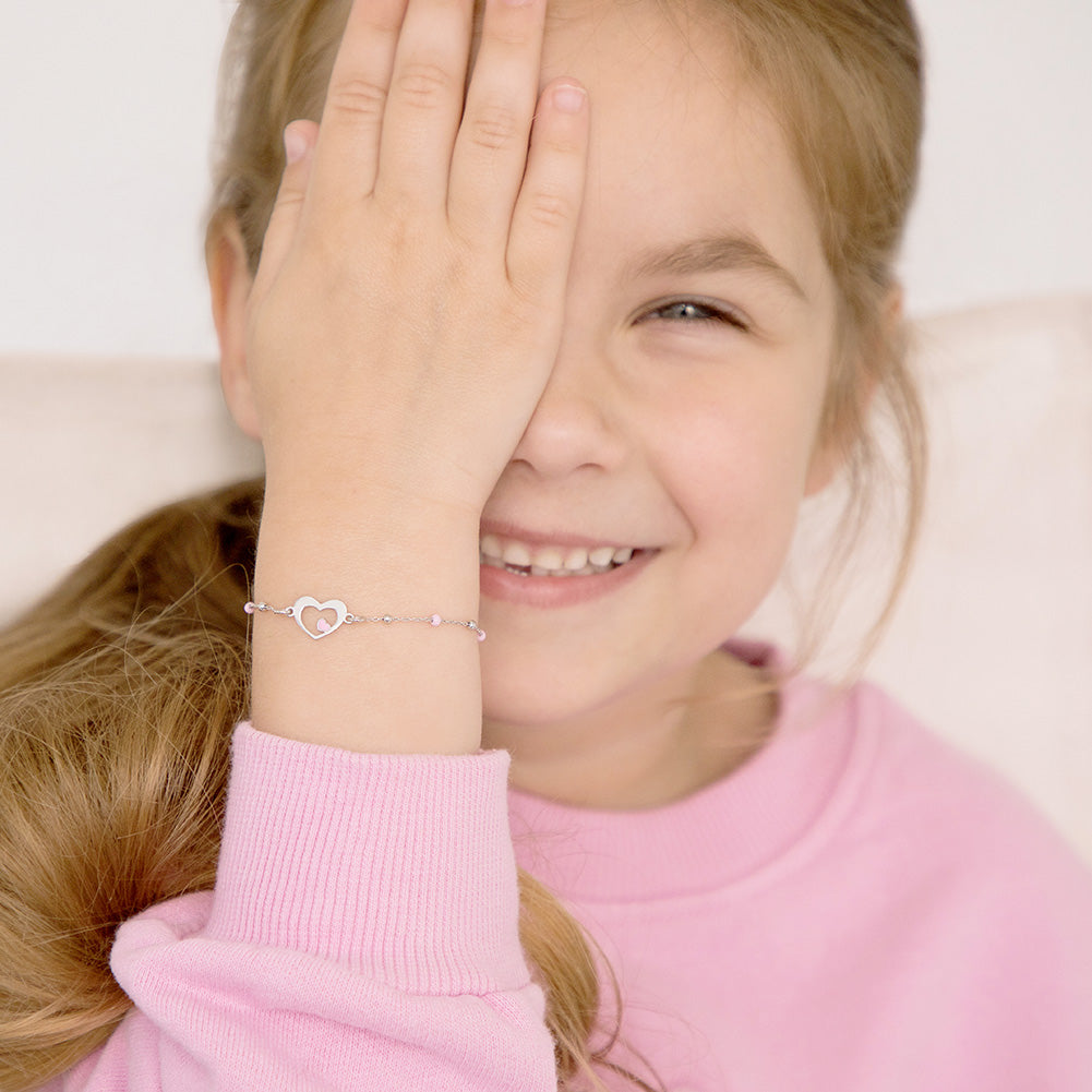 Age Group: Adorable for Toddlers, Young Girls & Preteens; Safe for Sensitive Skin
Material: 925 Sterling Silver
Bracelet Size: 5 inches with extension up to 6", heart & round beads (pink enamel); Adjustable
Metal Stamp: 925
Picture of young girl wearing silver heart bracelet