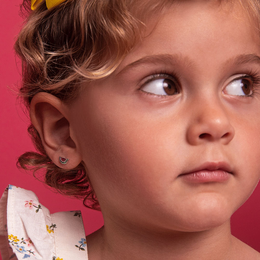 Age Group: Ideal for Toddlers and Little Girls
Size: 9mm W x 5mm H (green) watermelon; 7mm threaded earring post
Material: 925 Sterling Silver
Stone: Cubic Zirconia
Metal Stamp: 925
Window Box Included
picture of a little girl wearing the earrings