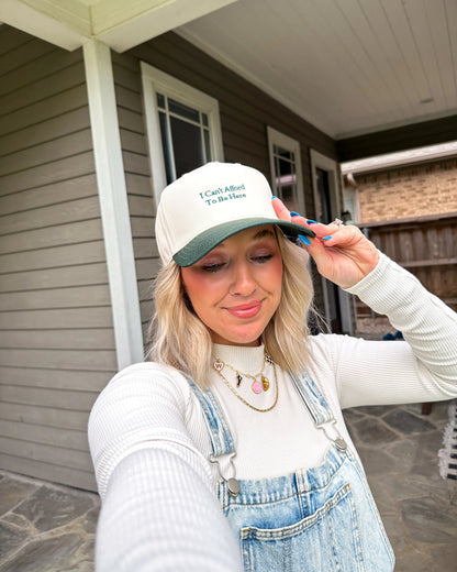 Woman wearing a cap and overalls standing on a porch