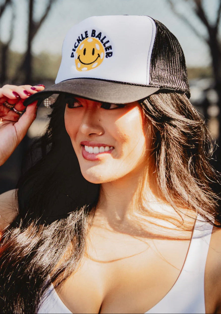 Woman wearing a cap with a smiley face design outdoors