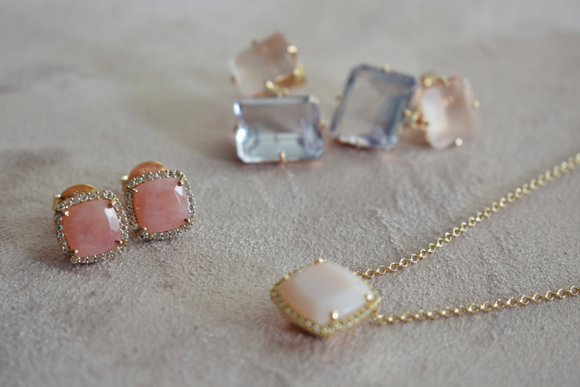 Jewelry set with pink stone necklace and earrings on a neutral background
