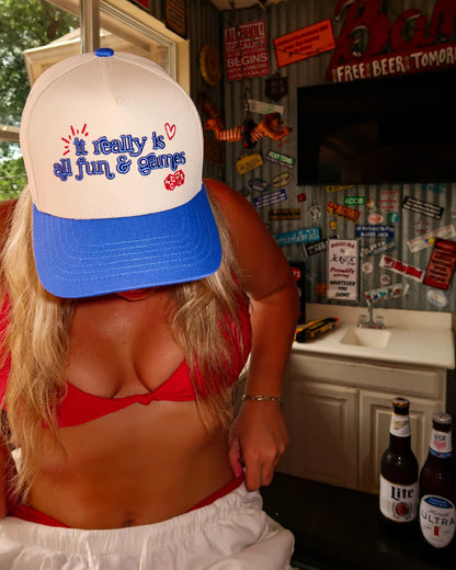 Person wearing a cap with text in a casual setting with beer bottles.