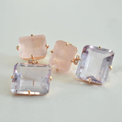 Pair of earrings with square gemstones on a light background