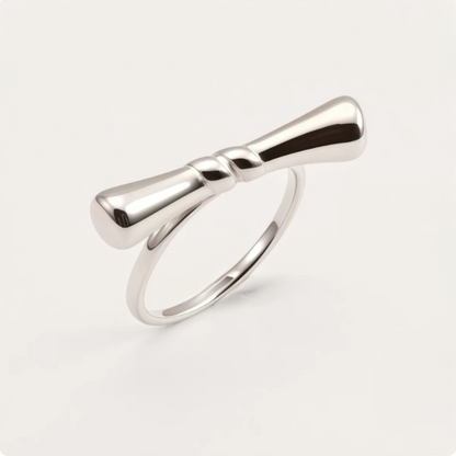 Silver bow-shaped ring on a light gray background