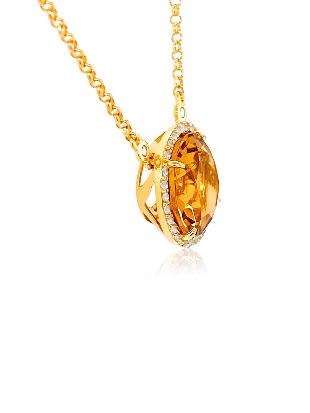 A gold pendant necklace featuring a marquise-cut orange gemstone surrounded by a halo of small clear stones, suspended from a gold chain on a white background.