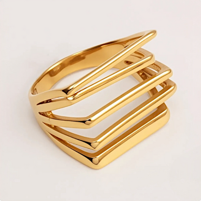 Gold ring with a geometric design on a light gray background