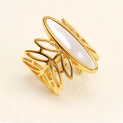 Gold ring with a white stone on a beige background