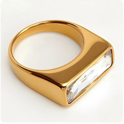 Gold ring with a large clear gemstone on a white background