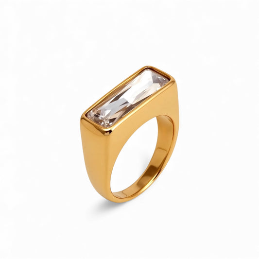 Gold ring with a rectangular gemstone on a white background