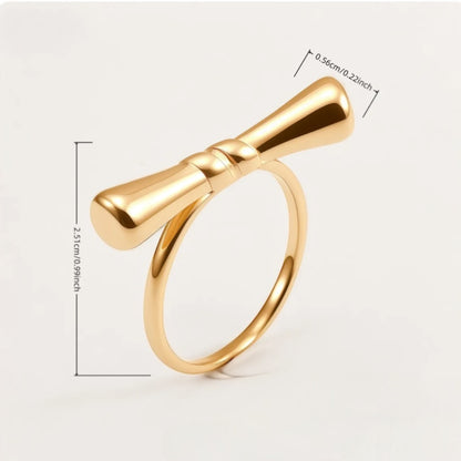 Gold bow-shaped ring with measurements on a white background