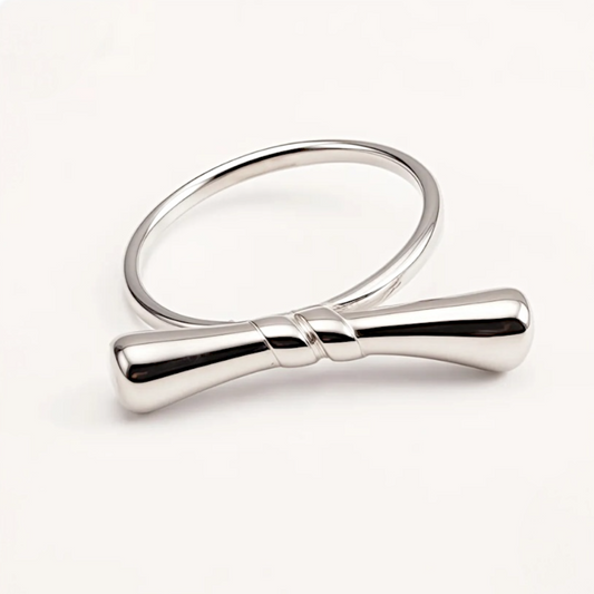 Silver ring with a bow design on a white background