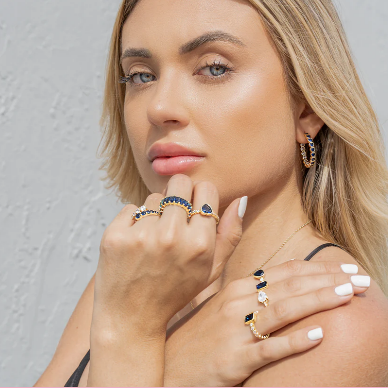 Blonde woman wearing multiple CZ gold rings