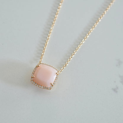 Necklace with a pink pendant on a marble surface