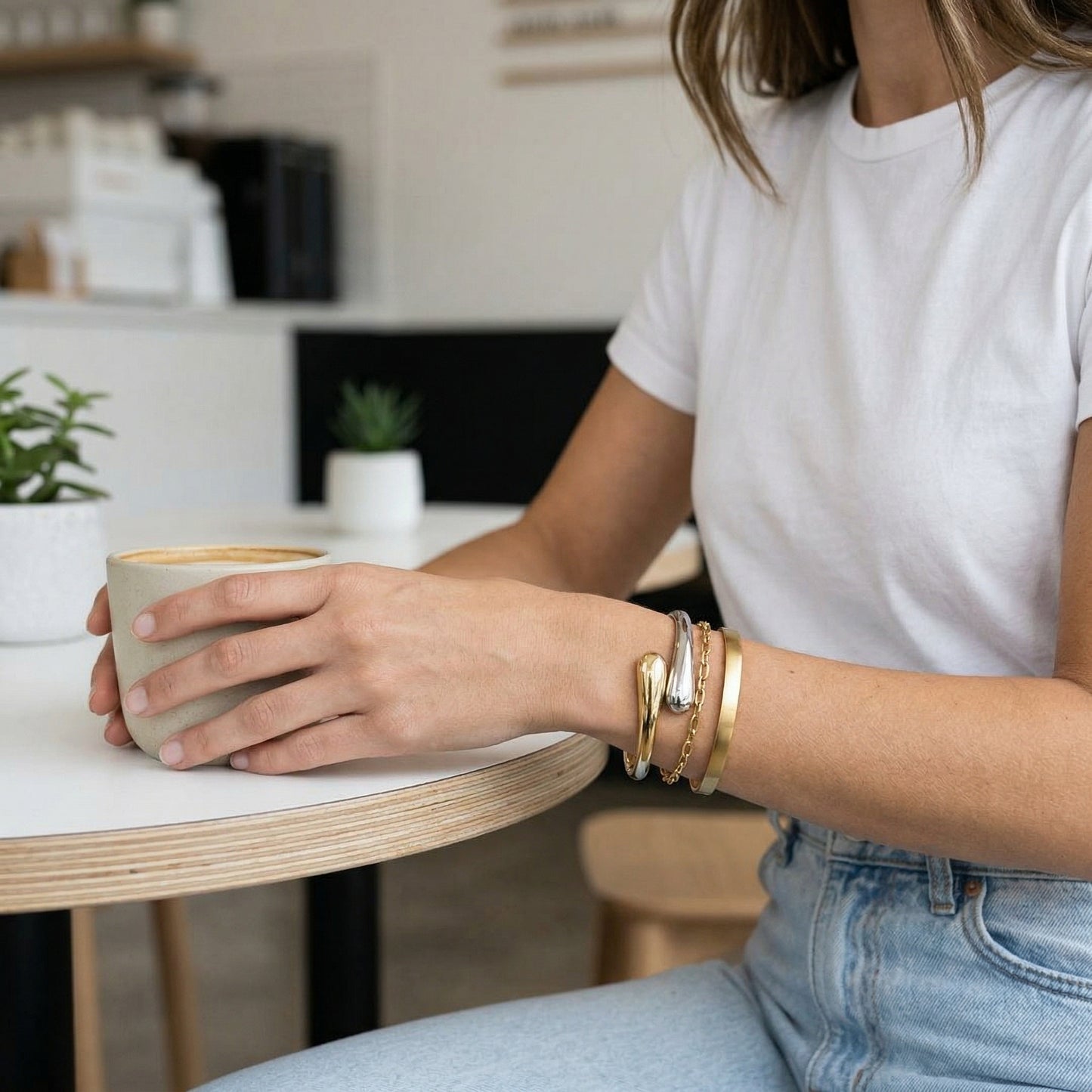 Person holding a mug with a blurred kitchen background