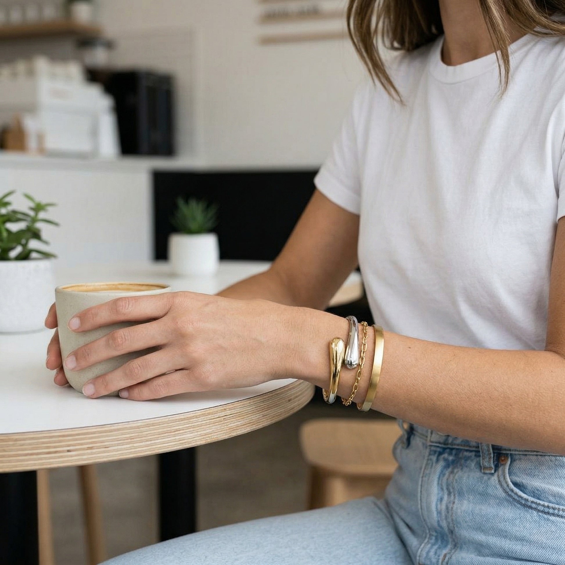 Person holding a mug with a blurred kitchen background