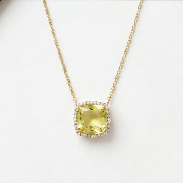 Necklace with a green gemstone pendant on a white surface.