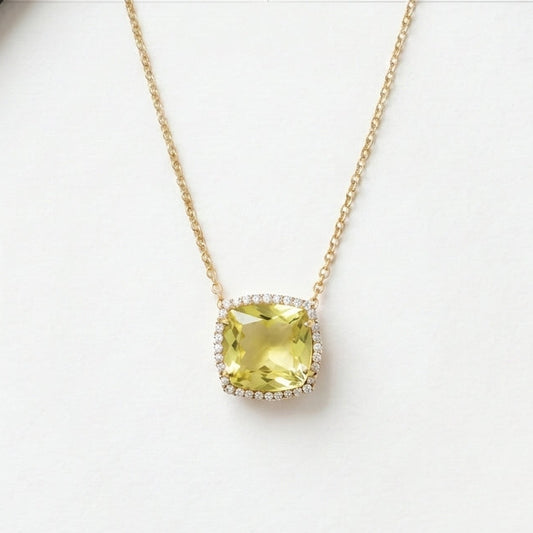Necklace with a green gemstone pendant on a white surface.