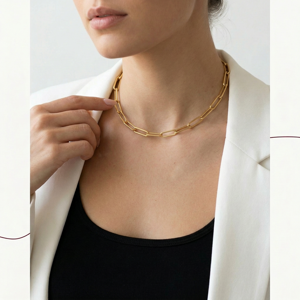 Person wearing a gold chain necklace with a plain background