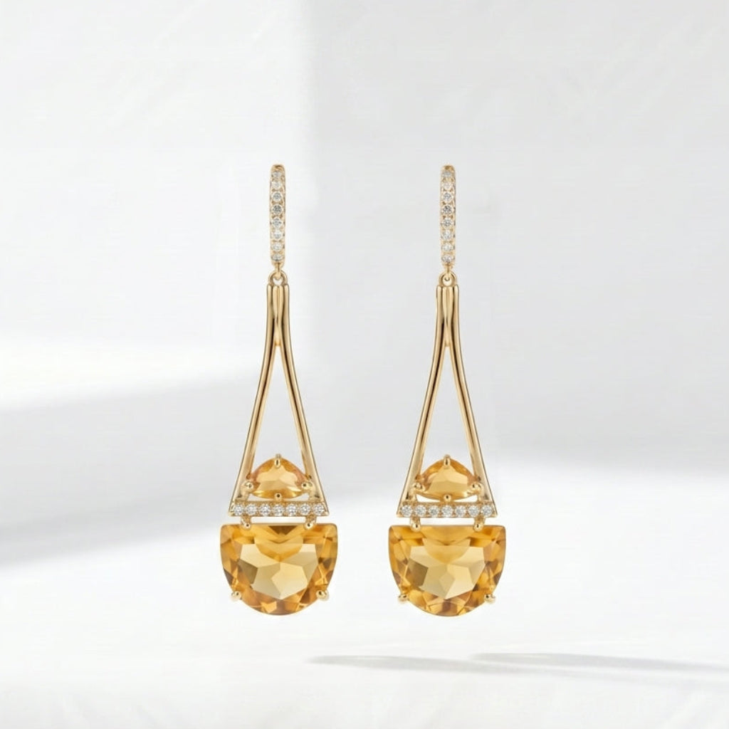 Gold earrings with yellow gemstones on a white background